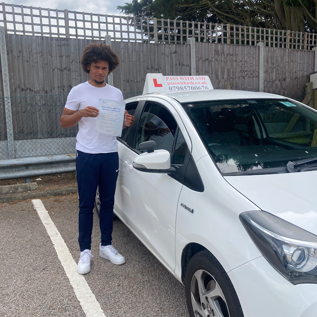 Driving pupil holding pass certificate by the Pass with Ash learner car in a parking area.