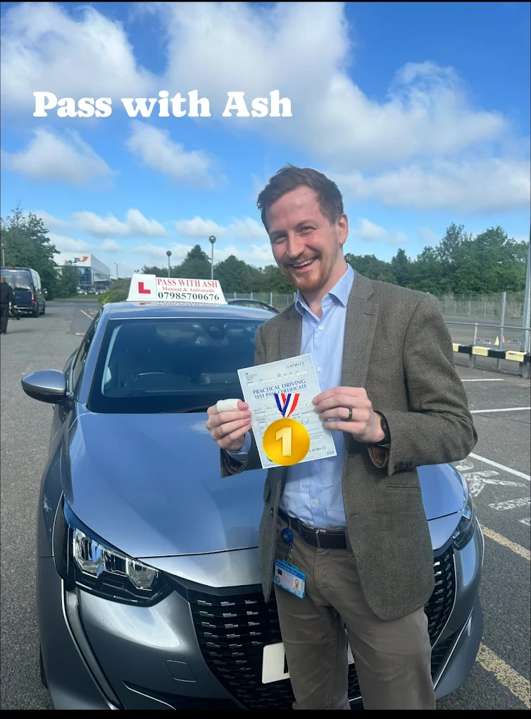 Successful pupil holding driving test certificate in front of the Pass with Ash car.